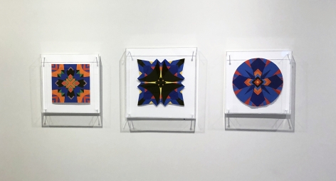 Three works on paper by Jack Youngerman under plexi box frames installed on a white wall