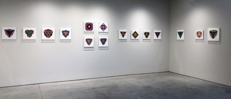 Fifteen works on paper by Jack Youngerman under plexi box frames installed on white walls