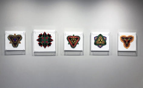 Five works on paper by Jack Youngerman under plexi box frames installed on a white wall