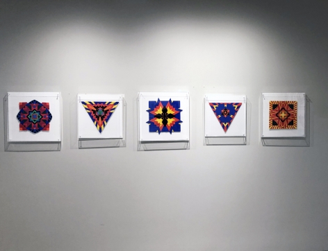 Five works on paper by Jack Youngerman under plexi box frames installed on a white wall
